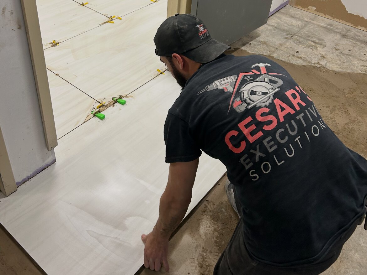 Cesar laying large-format tile on a commercial floor